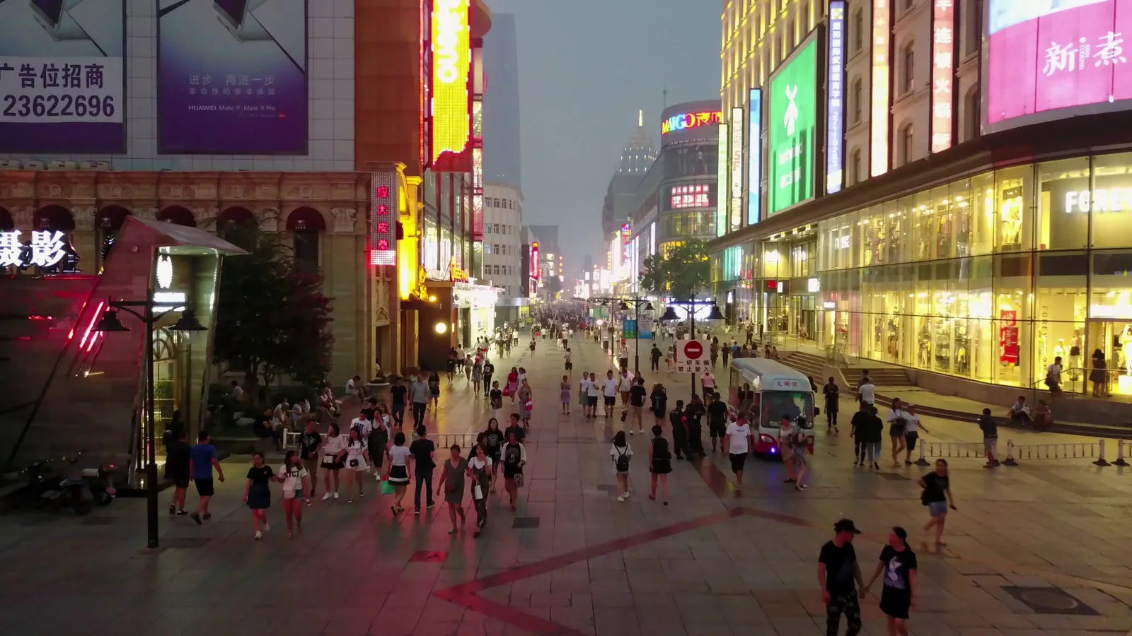 A busy shopping street seen from a low drone, with four people marked at different distances: 159, 107, 47 and 24 pixels tall.